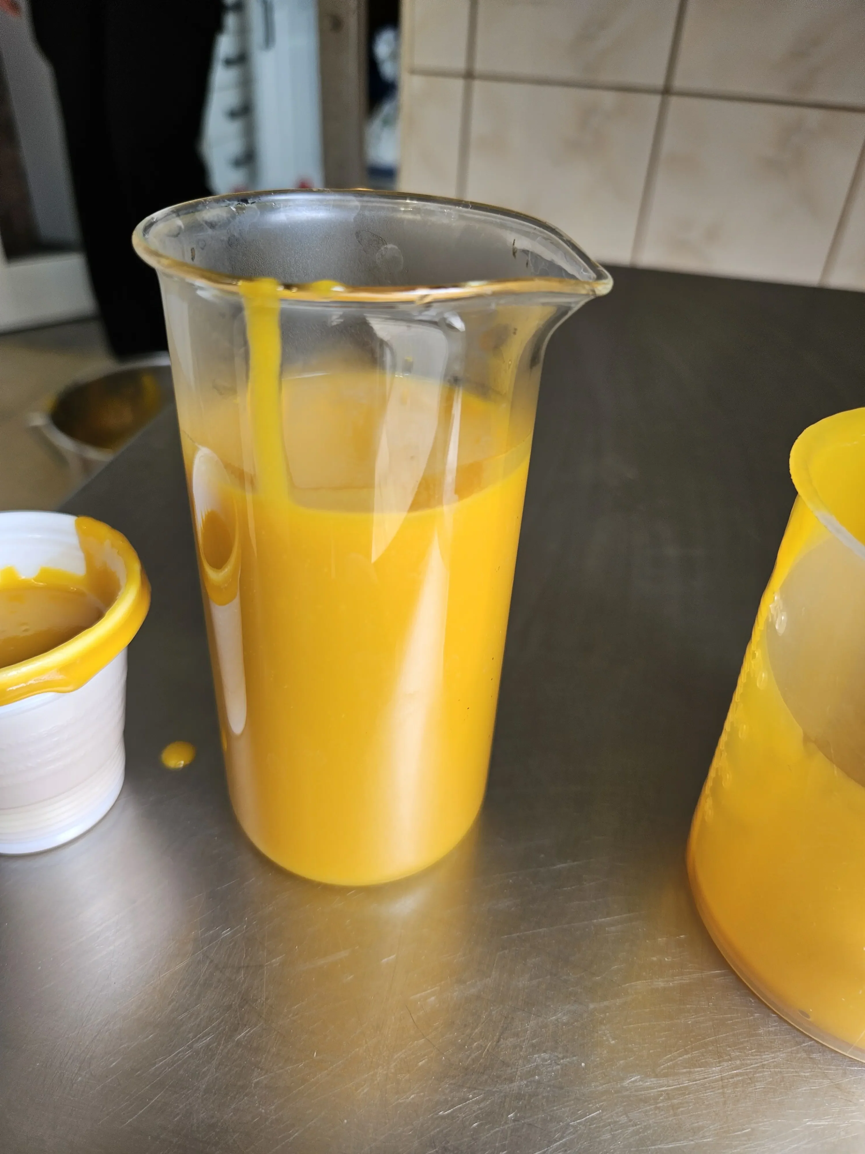 Mango pulp colour and texture in measuring cup – QC sample MG SALES