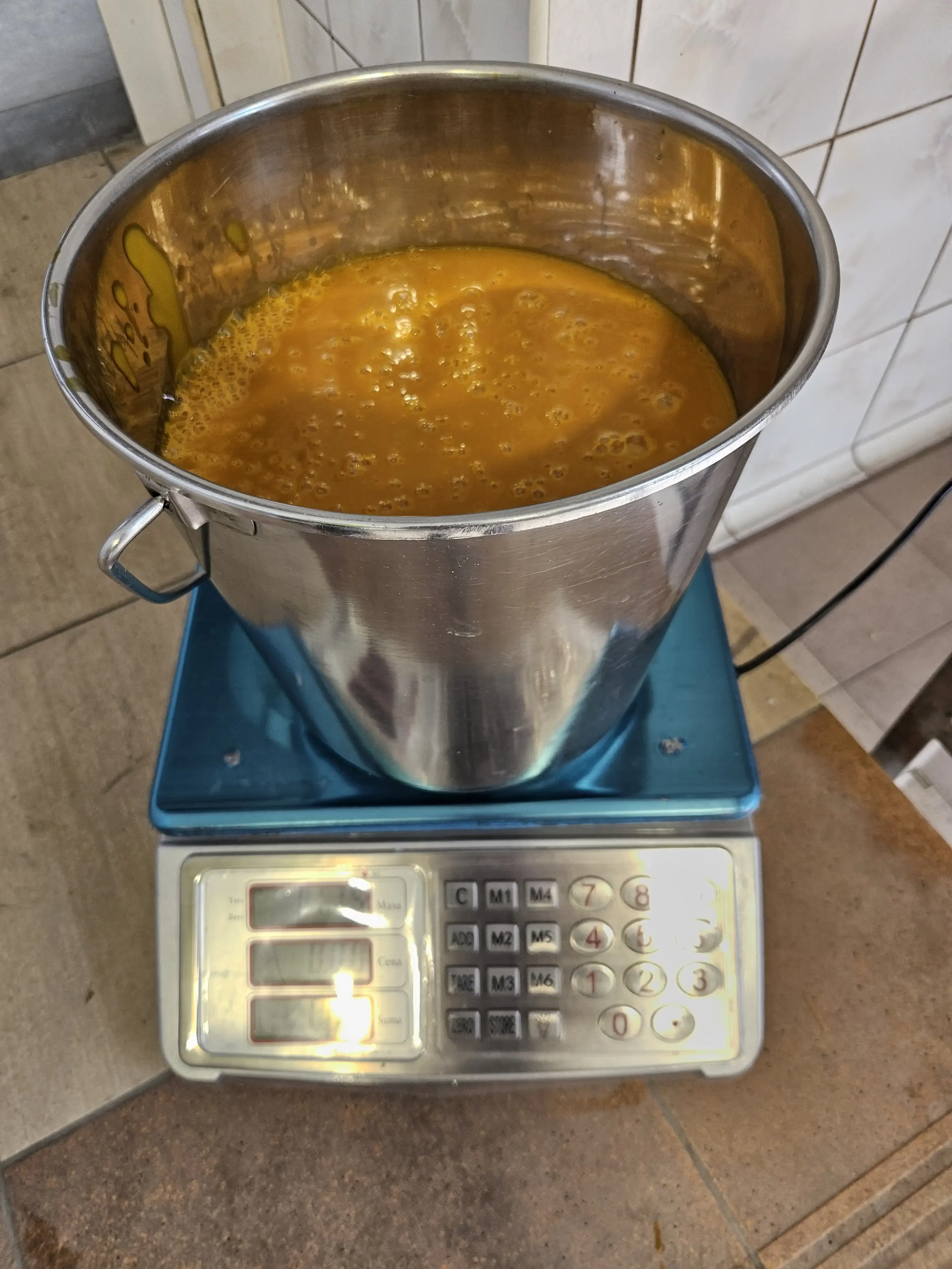 Mango pulp in stainless pot on scale – pre-shipment QC check